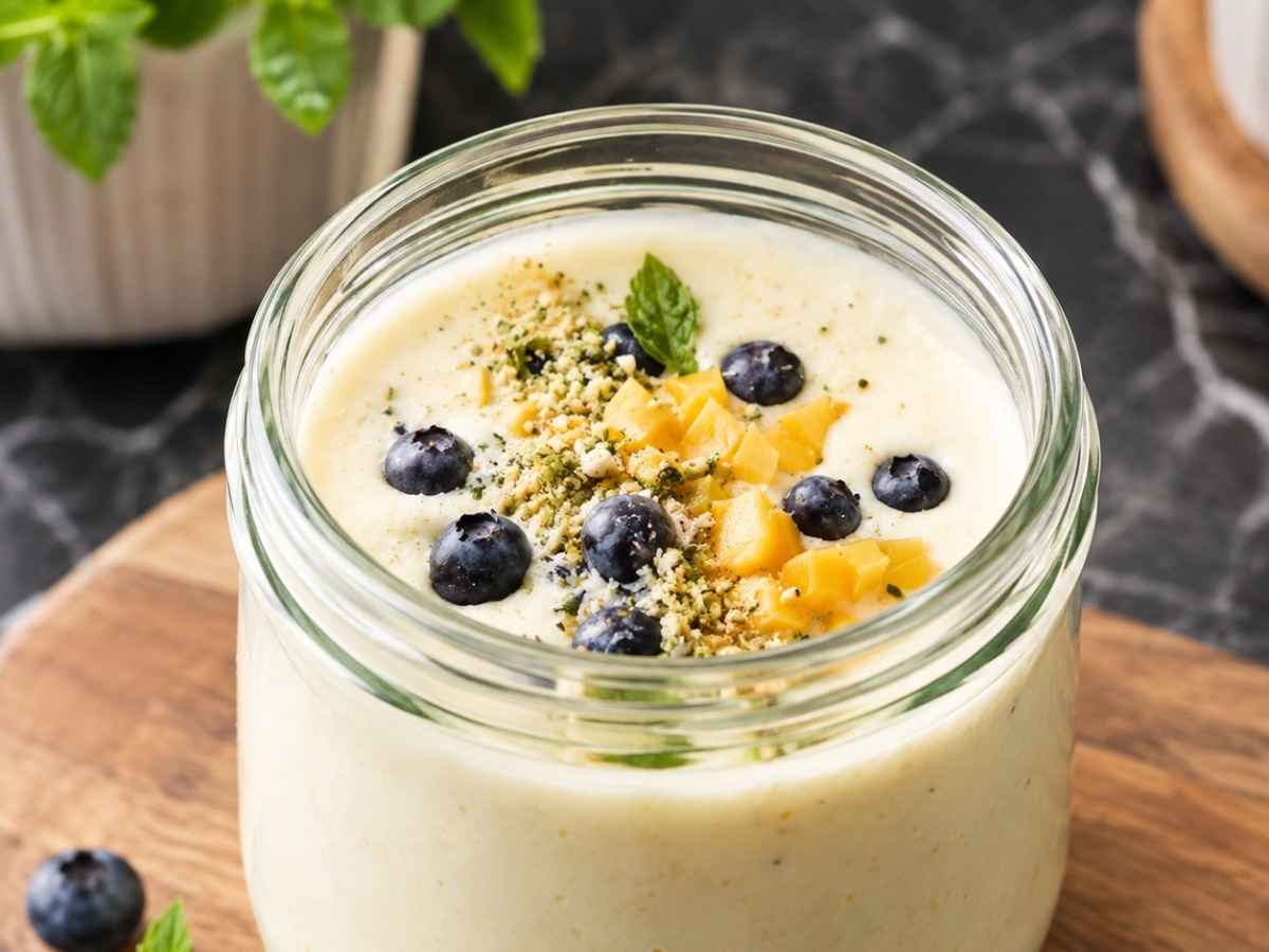 Nahaufnahme einer cremigen Buttermilch-Kaltschale mit Mangowürfeln und Minze