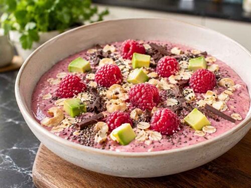 Himbeer-Smoothie Bowl mit Chiasamen, garniert mit Cashewkernen, Haferflocken und frischen Himbeeren