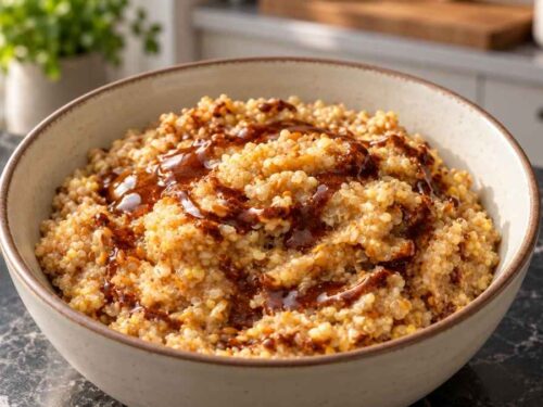 Schale Porridge mit Kardamom-Zimt-Drizzle, mit Beeren und Kürbiskernen auf einem Holztisch serviert